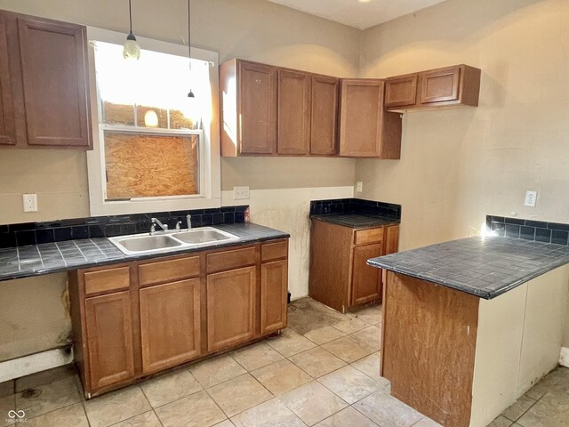 kitchen featuring sink, light tile patterned floors, and decorative light fixtures