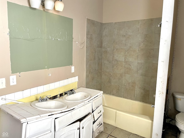 full bathroom with tiled shower / bath combo, vanity, tile patterned floors, and toilet