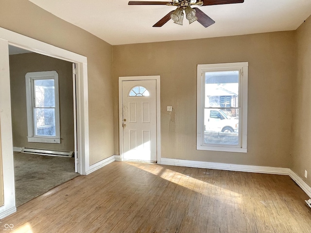 entrance foyer with hardwood / wood-style floors, ceiling fan, and baseboard heating