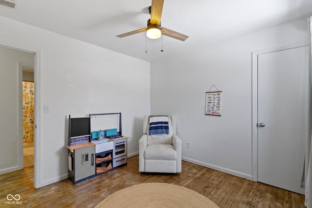 living area featuring ceiling fan and hardwood / wood-style flooring