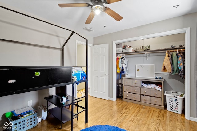 bedroom with a closet, light hardwood / wood-style flooring, and ceiling fan