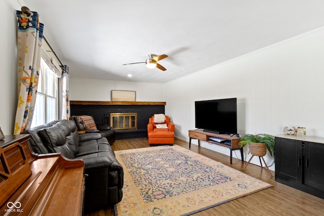 living room with ceiling fan, a fireplace, and hardwood / wood-style floors