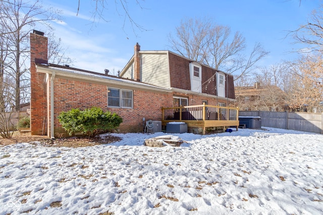 snow covered rear of property featuring a wooden deck