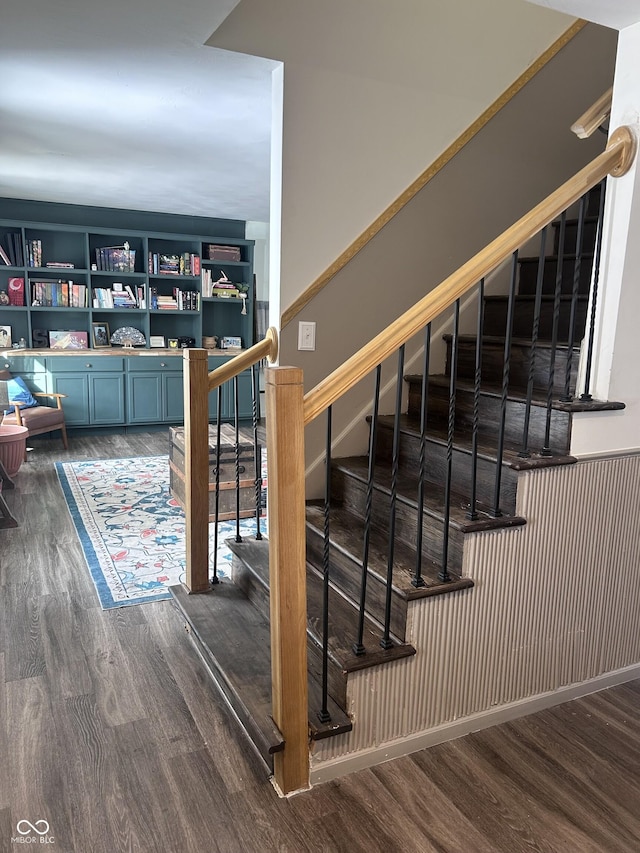 stairway featuring built in shelves and hardwood / wood-style floors