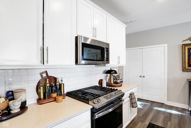 kitchen with tasteful backsplash, dark wood-type flooring, stainless steel appliances, and white cabinets