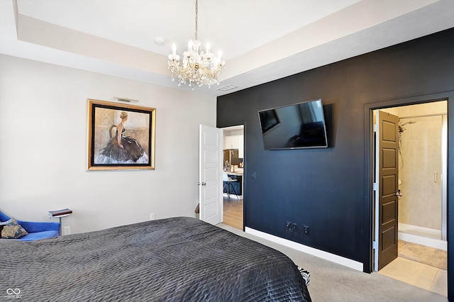 carpeted bedroom with a notable chandelier and a tray ceiling