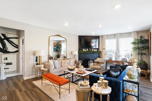 living room featuring a tile fireplace and dark hardwood / wood-style floors