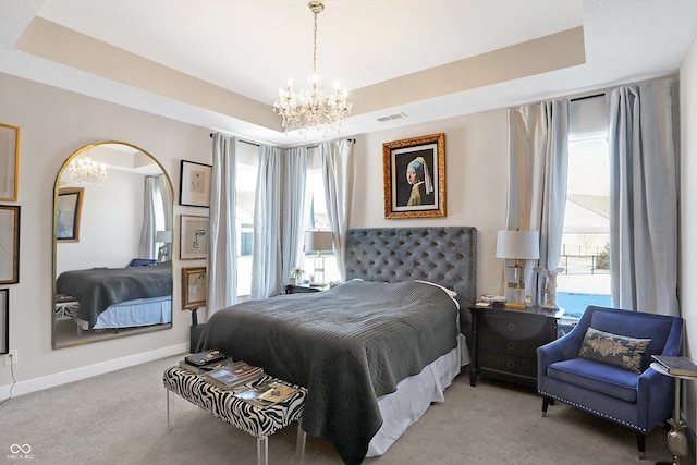 bedroom with a raised ceiling, light carpet, and an inviting chandelier