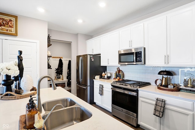 kitchen featuring white cabinetry, stainless steel appliances, sink, and tasteful backsplash