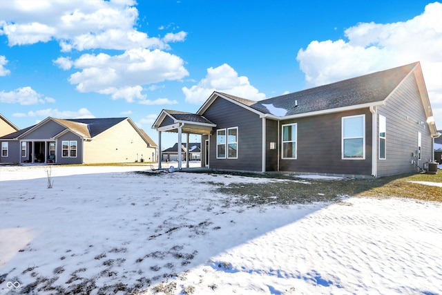 snow covered house featuring central AC