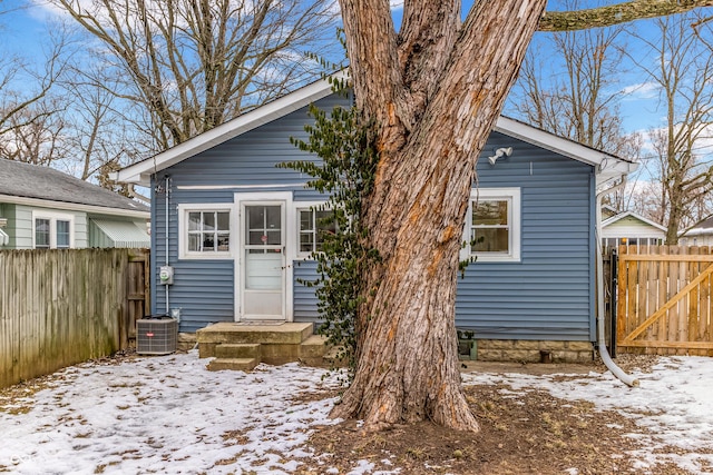 snow covered house with central AC unit