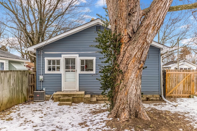 snow covered rear of property featuring central air condition unit