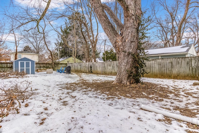 yard layered in snow featuring a storage shed