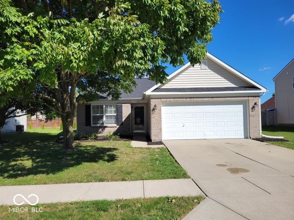 ranch-style house with a garage and a front yard