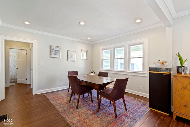 dining room with dark hardwood / wood-style flooring and ornamental molding