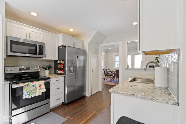 kitchen with sink, stainless steel appliances, white cabinetry, and backsplash