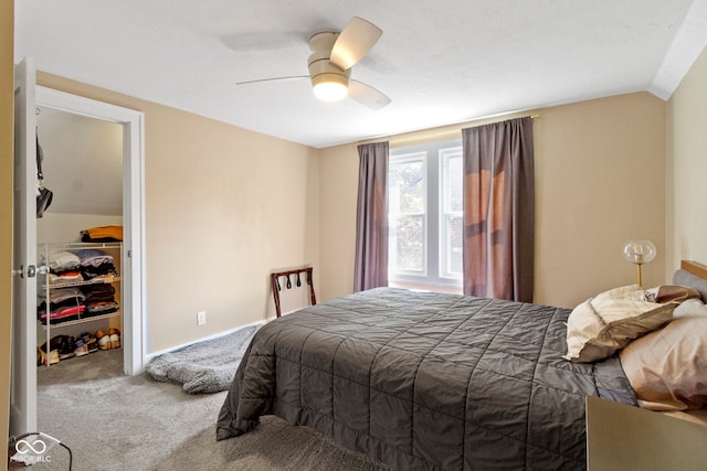 bedroom with carpet flooring, a spacious closet, vaulted ceiling, a closet, and ceiling fan