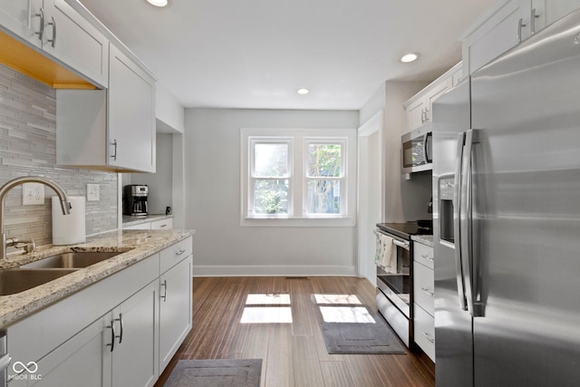 kitchen featuring sink, white cabinets, tasteful backsplash, and stainless steel appliances