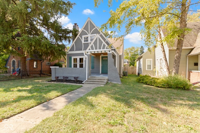 tudor house featuring central AC unit and a front lawn