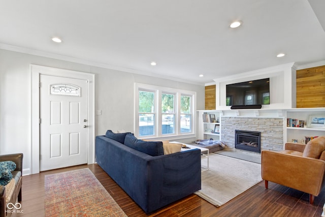 living room featuring crown molding, a stone fireplace, and dark hardwood / wood-style flooring