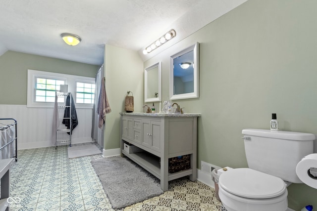 bathroom featuring a textured ceiling, toilet, and vanity