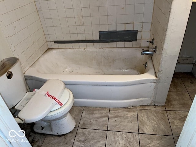 bathroom with a washtub, tile patterned floors, and toilet