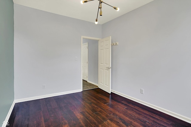 386 White Oak Ln, Greenwood, IN 46142 - empty room featuring an inviting chandelier, baseboards, and wood finished floors