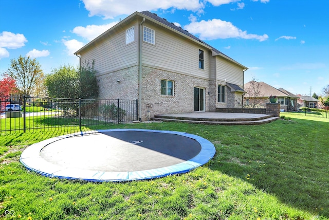 386 White Oak Ln, Greenwood, IN 46142 - rear view of property featuring a lawn, brick siding, fence, a trampoline, and a patio area