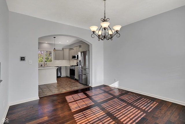386 White Oak Ln, Greenwood, IN 46142 - unfurnished dining area with arched walkways, dark wood-style floors, baseboards, and a sink