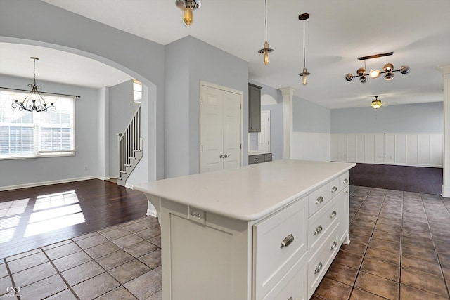 386 White Oak Ln, Greenwood, IN 46142 - kitchen with dark tile patterned floors, ceiling fan with notable chandelier, open floor plan, a kitchen island, and light countertops