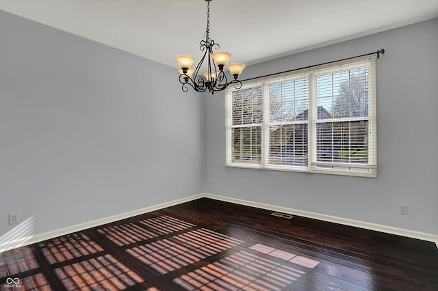 386 White Oak Ln, Greenwood, IN 46142 - empty room with baseboards, an inviting chandelier, and wood finished floors