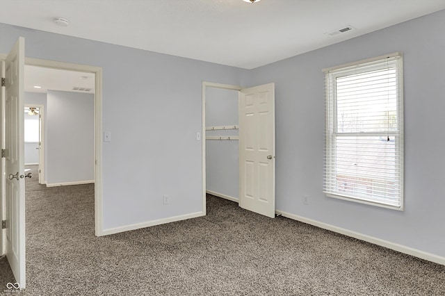 386 White Oak Ln, Greenwood, IN 46142 - unfurnished bedroom featuring baseboards, a spacious closet, and carpet floors