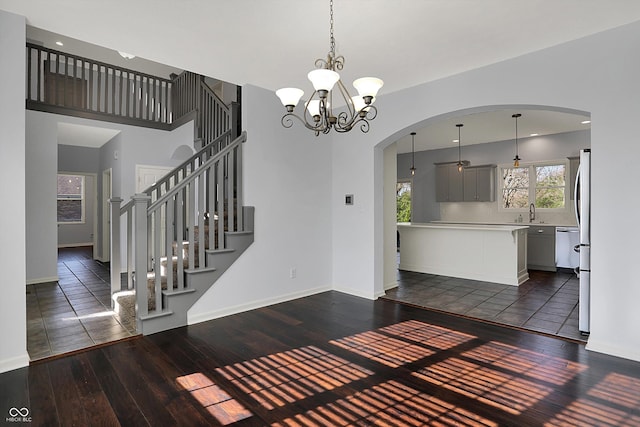 386 White Oak Ln, Greenwood, IN 46142 - interior space with hardwood / wood-style floors, baseboards, arched walkways, and a notable chandelier