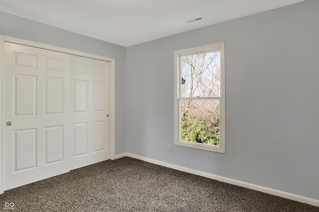 386 White Oak Ln, Greenwood, IN 46142 - unfurnished bedroom with baseboards, dark carpet, multiple windows, and visible vents