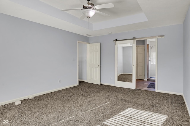 386 White Oak Ln, Greenwood, IN 46142 - unfurnished bedroom featuring carpet, a barn door, a ceiling fan, a raised ceiling, and baseboards