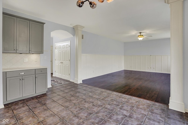 386 White Oak Ln, Greenwood, IN 46142 - interior space with gray cabinets, decorative columns, ceiling fan, decorative backsplash, and wainscoting