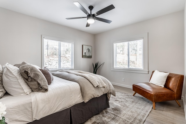 bedroom featuring multiple windows, ceiling fan, and light hardwood / wood-style floors