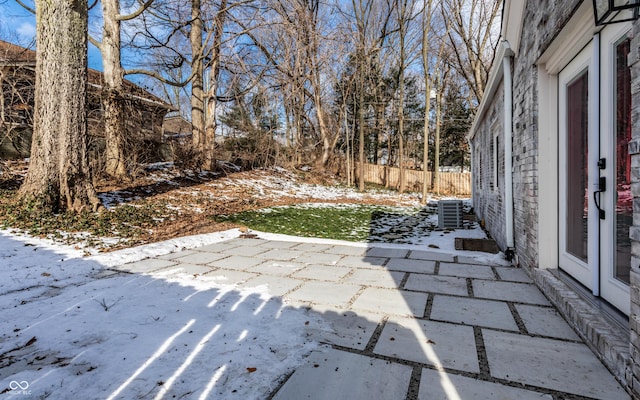 snow covered patio featuring central air condition unit