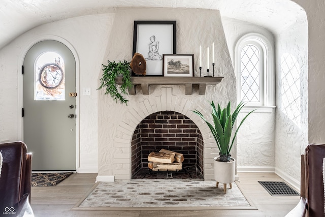 foyer entrance featuring light hardwood / wood-style flooring and a fireplace