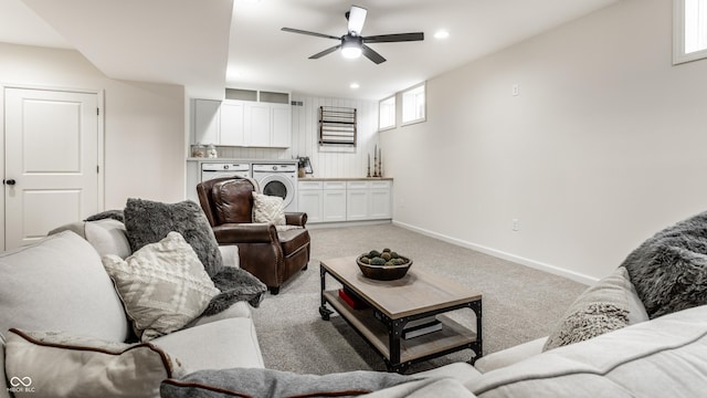 carpeted living room featuring washer and dryer, sink, and ceiling fan