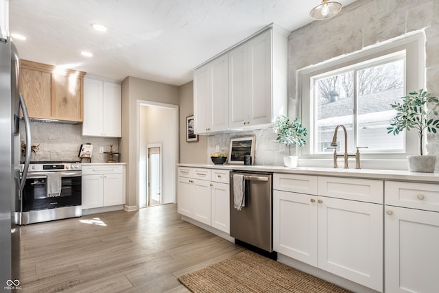 kitchen featuring white cabinetry, light hardwood / wood-style flooring, and appliances with stainless steel finishes