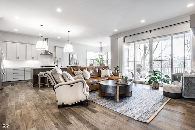 living area with a healthy amount of sunlight, ornamental molding, and dark wood-type flooring