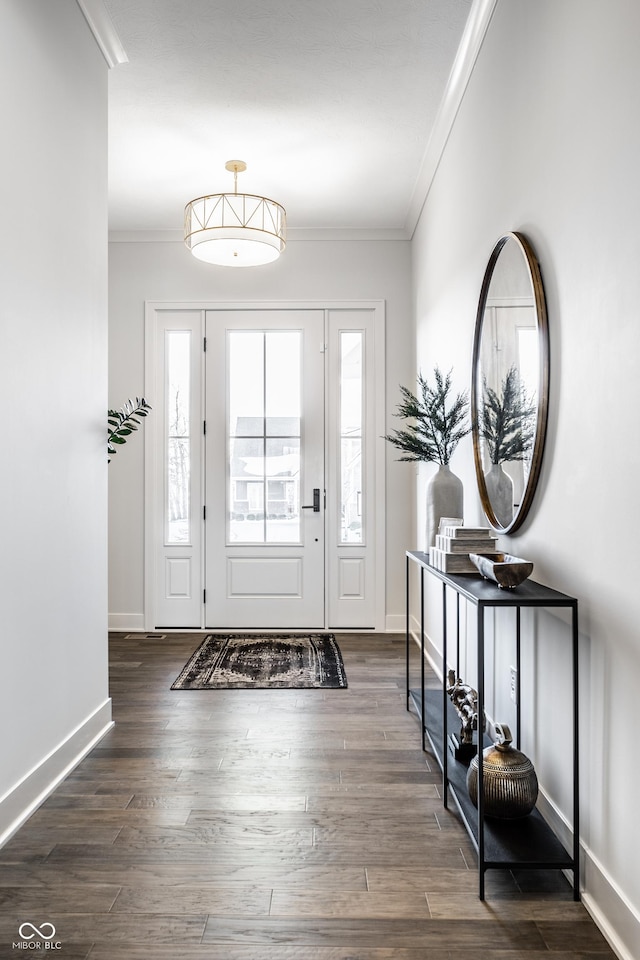 foyer with baseboards, ornamental molding, and dark wood finished floors