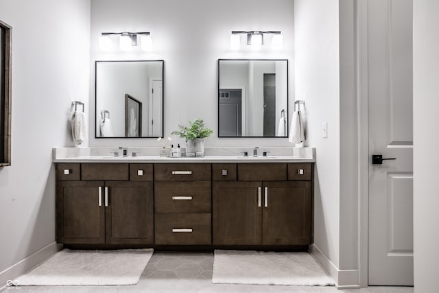 bathroom with double vanity, baseboards, and a sink