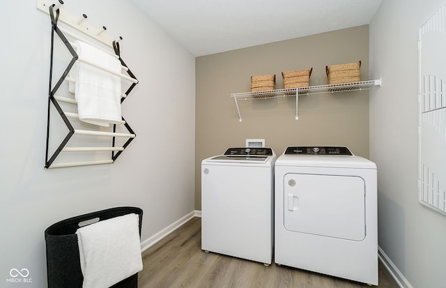 laundry room with light wood-type flooring and washer and clothes dryer