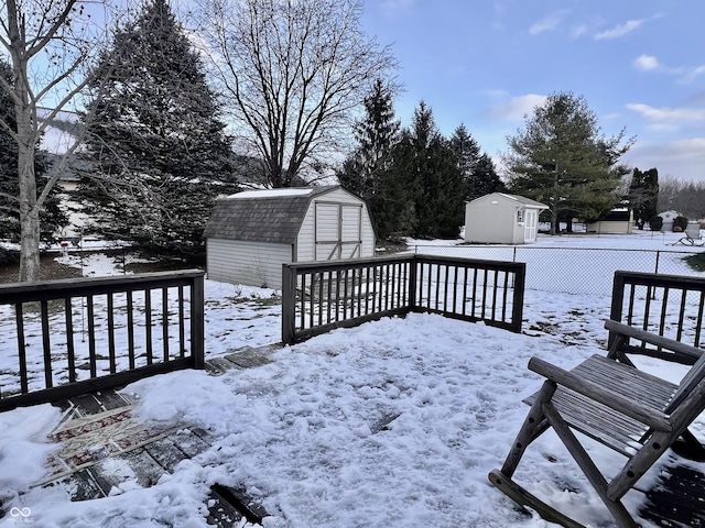 snow covered deck featuring a shed