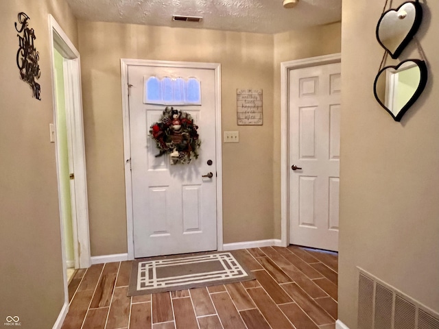 doorway featuring a textured ceiling