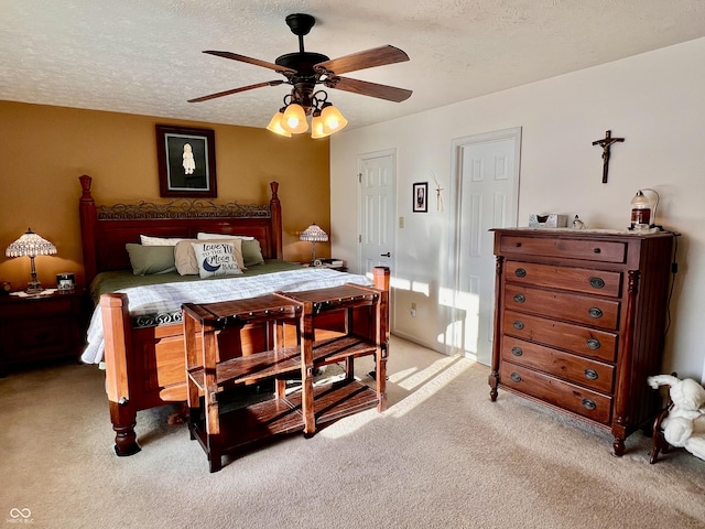 bedroom featuring ceiling fan, a textured ceiling, and light carpet