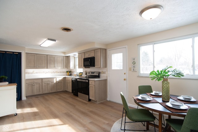 kitchen with black appliances, light wood-type flooring, tasteful backsplash, and light brown cabinets