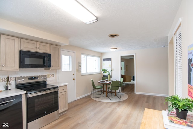 kitchen featuring light brown cabinets, black appliances, a textured ceiling, and light hardwood / wood-style flooring